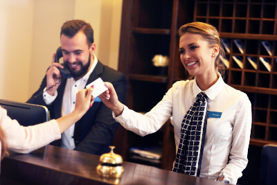 A concierge passing information to a hotel guest