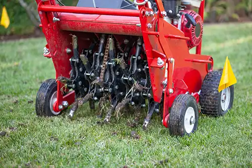 Lawn aeration machine running on grass - Keep pests away from your lawn with Arrow Exterminators in OK
