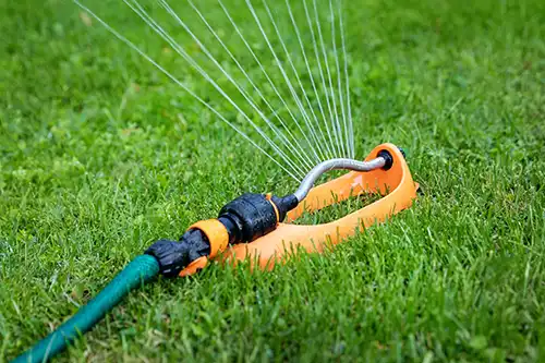 Lawn sprinkler spreading water - Keep pests away from your lawn with Arrow Exterminators in OK