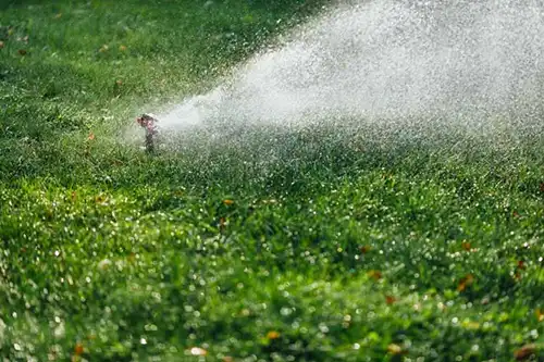 Water sprinkler spreading water on a lawn - Keep pests away from your lawn with Arrow Exterminators in OK